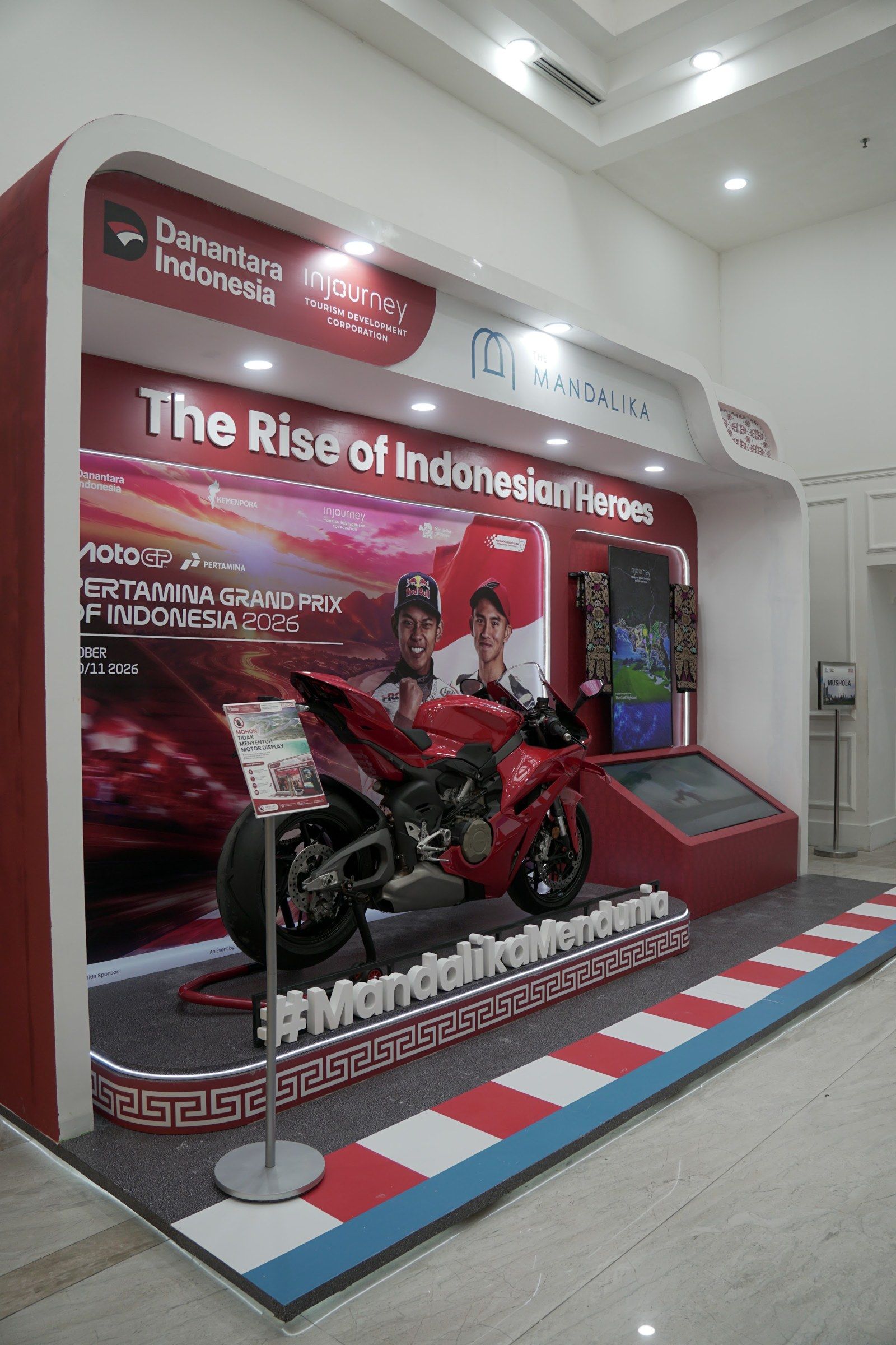 The booth with the MotoGP bike on a racing-kerb podium
